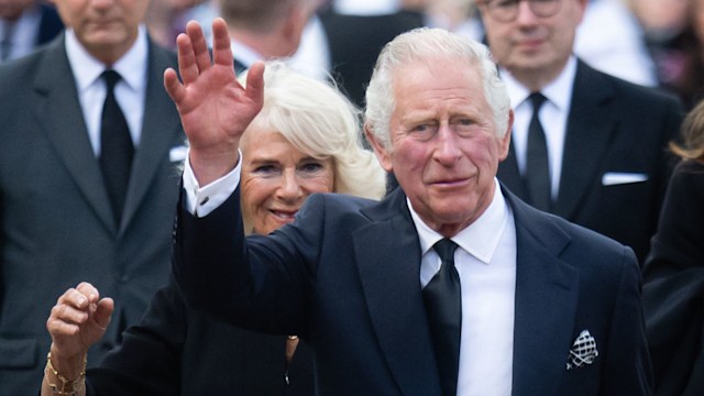 King Charles waving in a dark suit 