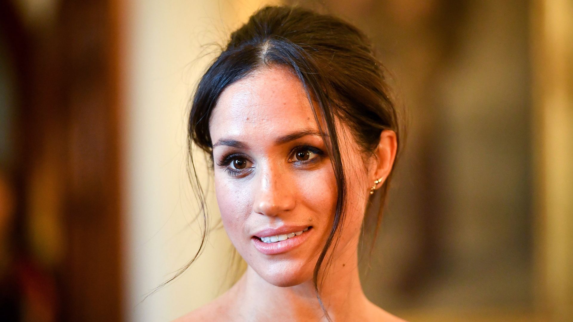 Meghan Markle with her hair in a slightly undone updo 