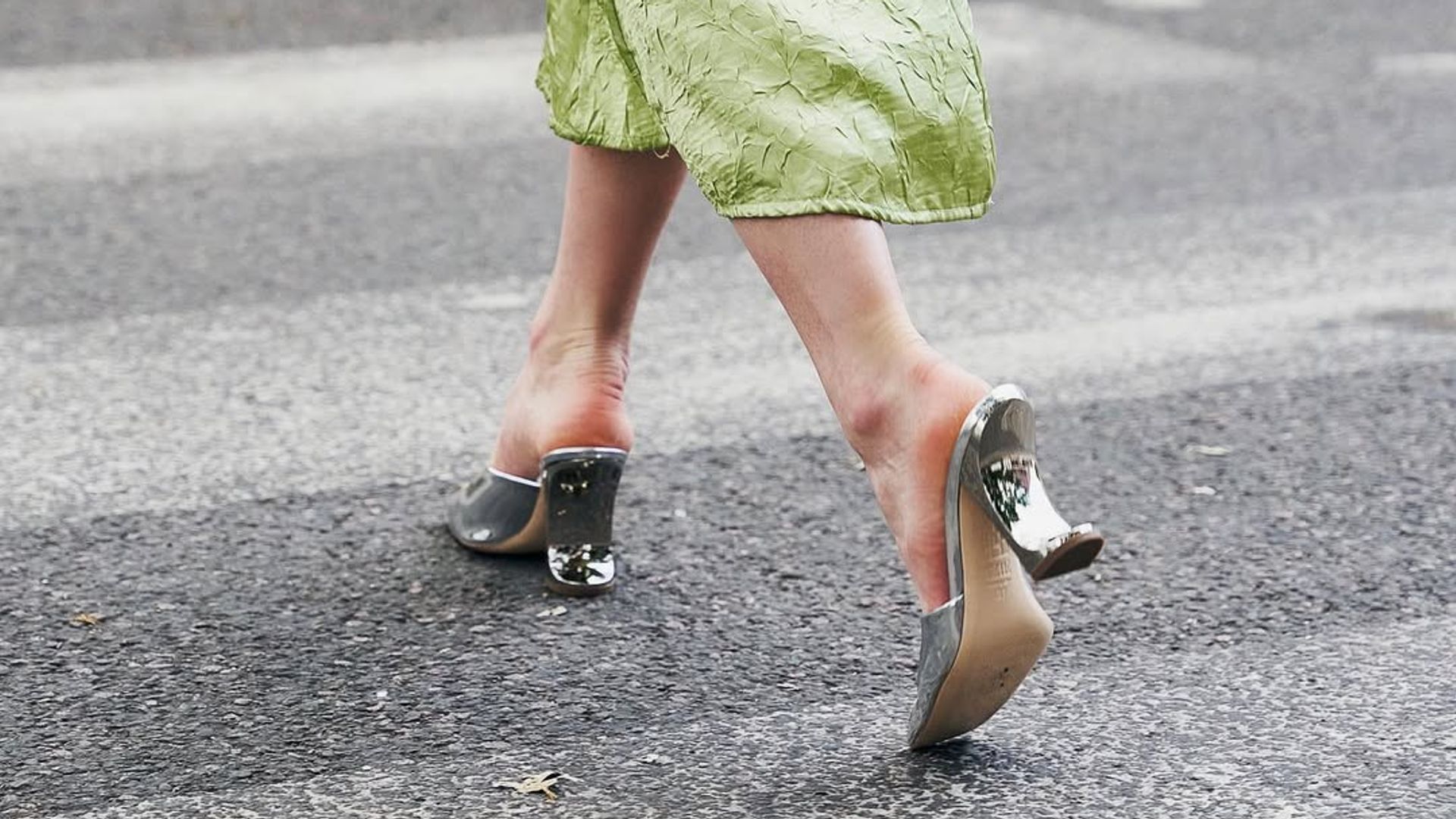 women in silver heels and green skirt
