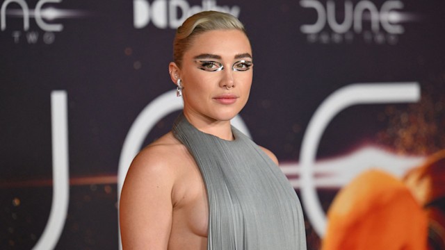 Florence Pugh with silver reflective eye stickers in backless grey dress 