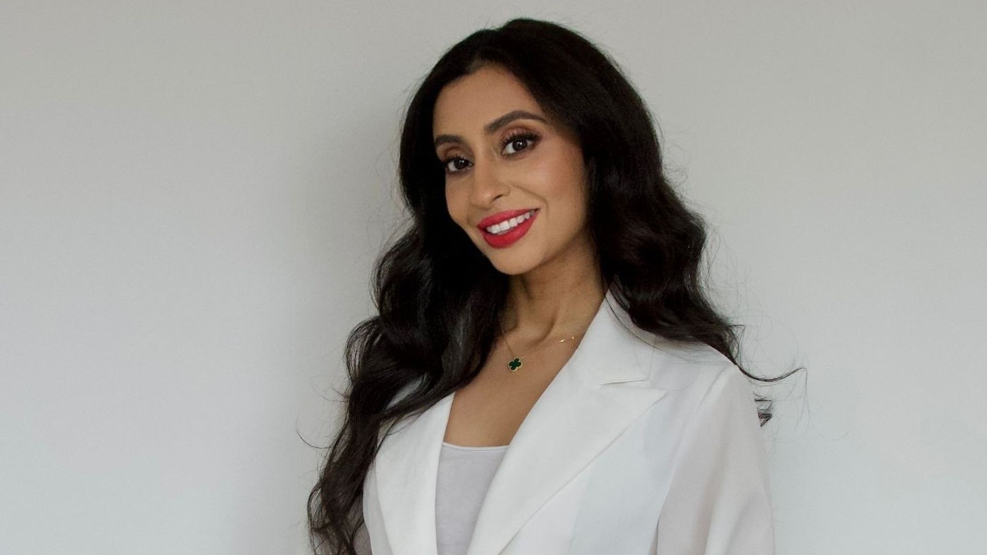Brunette woman smiling in a white blazer