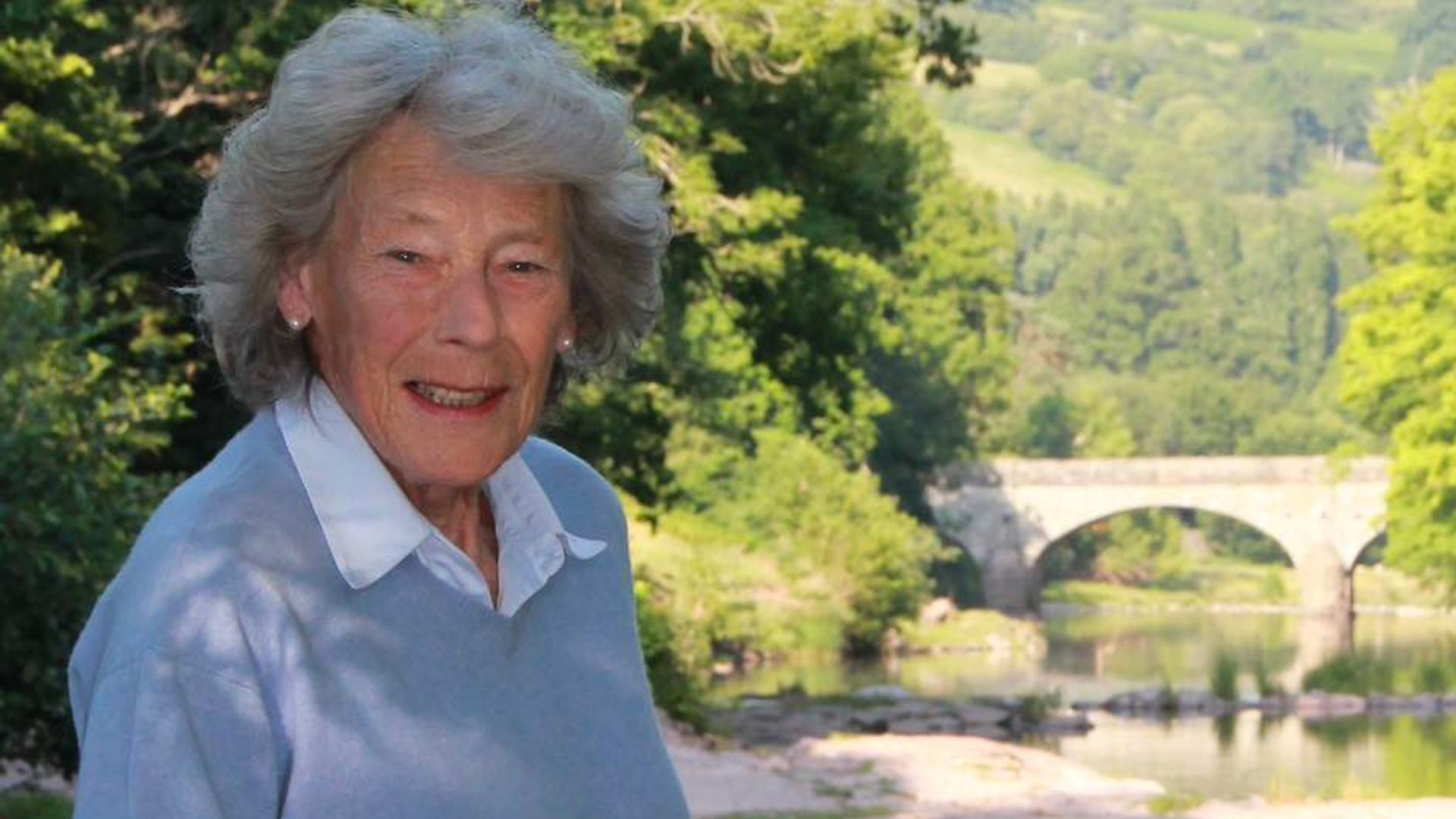 Dame Shan Legge-Bourke with a walking stick in front of a river