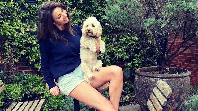 woman sitting with a fluffy dog 