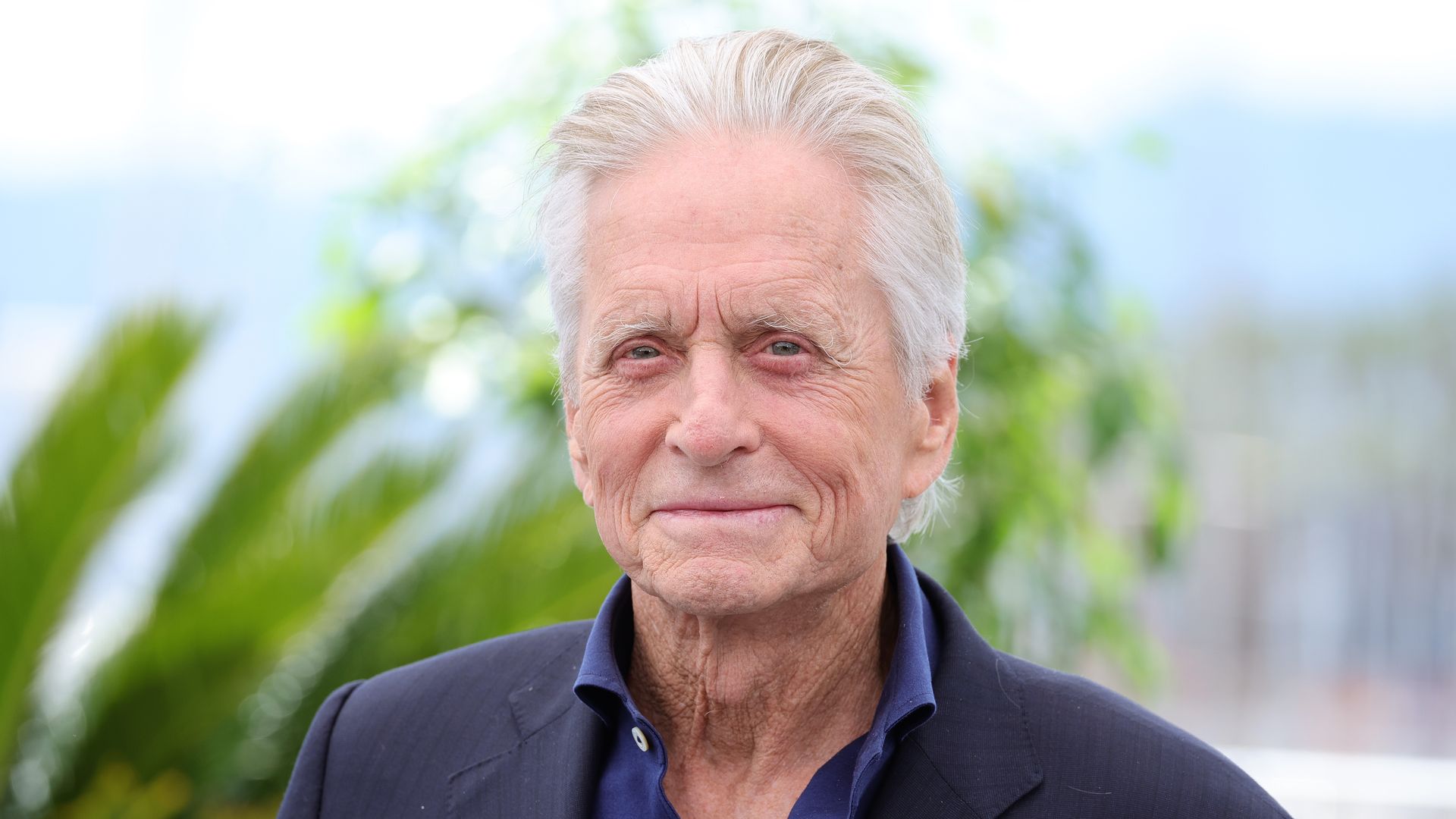 MIchael Douglas smiling tropical backdrop