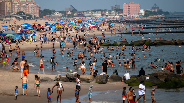 People try to stay cool at the beach at Coney Island in Brooklyn as the region experiences another heatwave on July 30, 2025 in New York City. Temperatures are expected to reach into the high 90s with a heat index well above 100 degrees. (Photo by Spencer Platt/Getty Images)