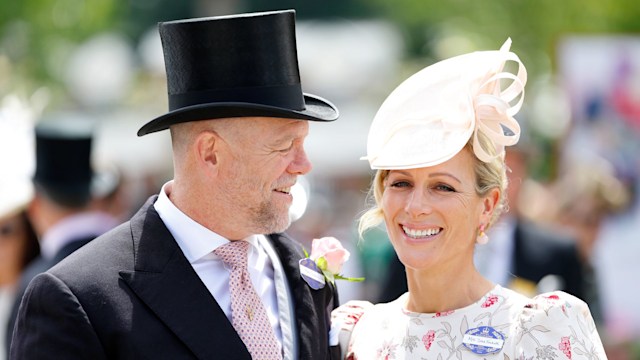 Mike Tindall in a suit and top hat looking at Zara Tindall in a floral dress