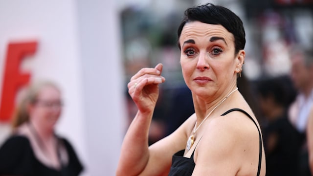 Amanda Abbington  in a black dress looking over her shoulder