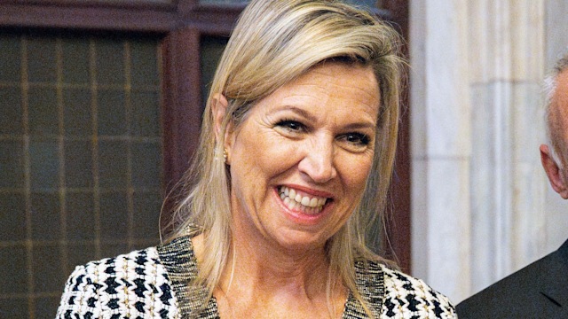 Queen Maxima smiling in a tweed dress