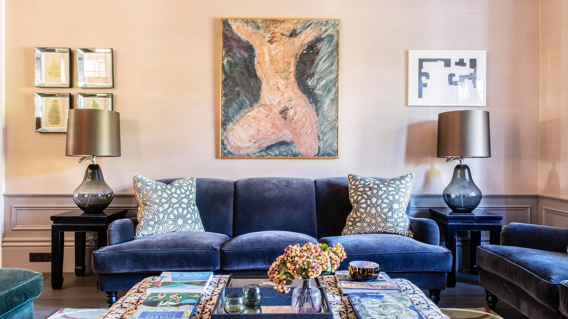 living room with blue sofa, printed ottoman and wall art