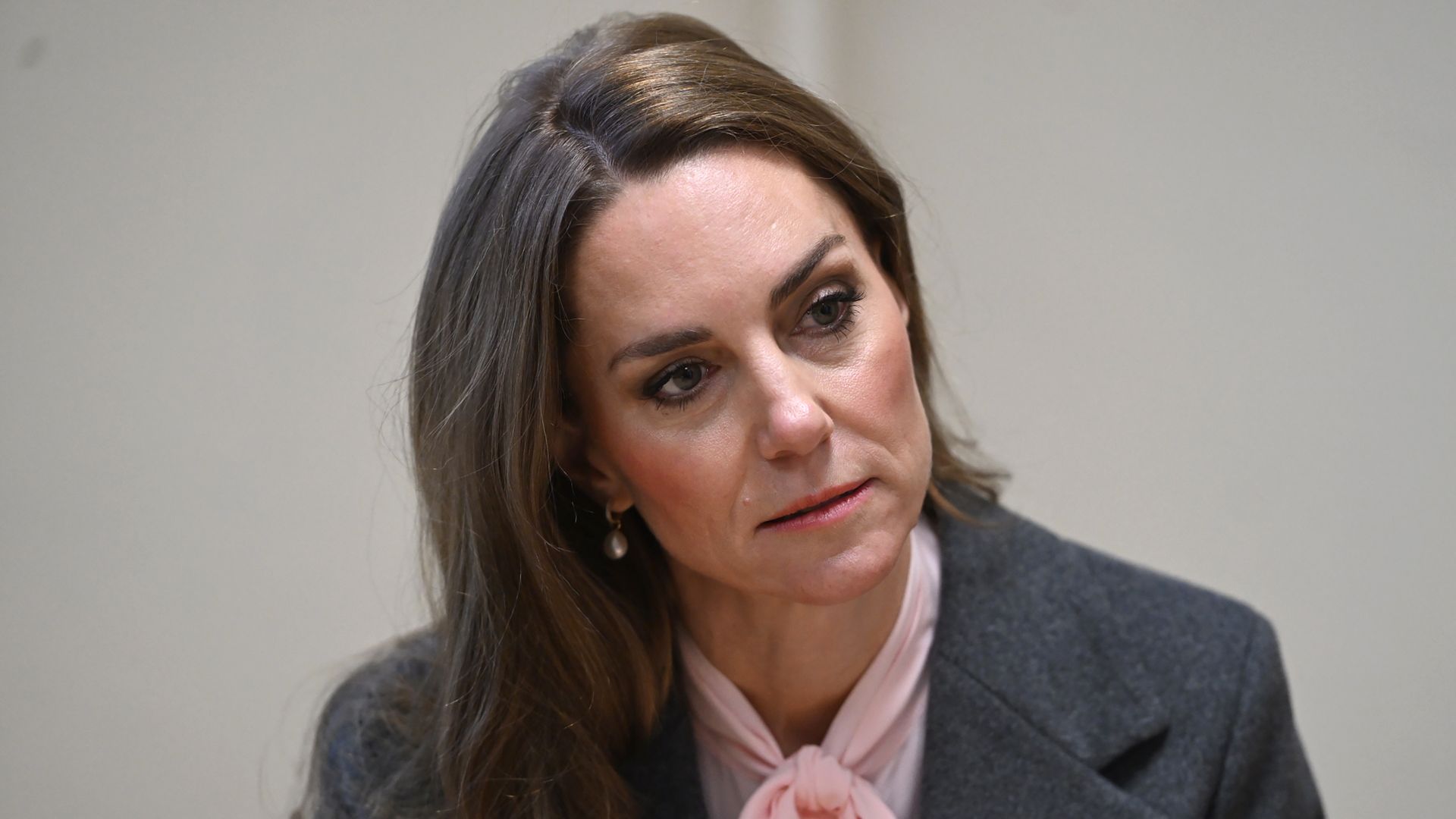 Catherine, Princess of Wales looking serious in pink blouse and grey coat