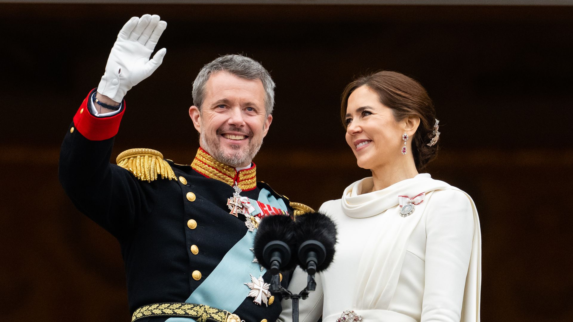 King Frederik waves from balcony with Queen Mary