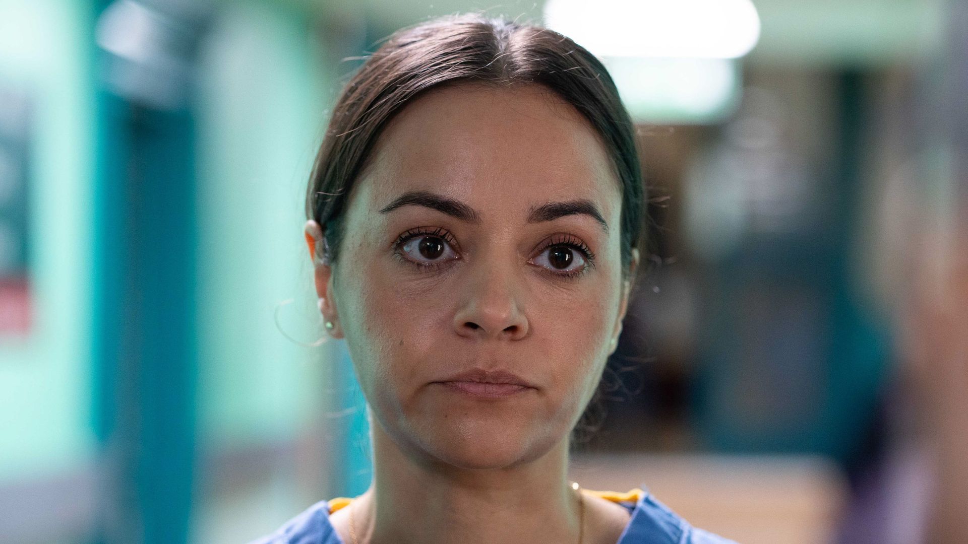 Woman in nurses uniform looking past camera
