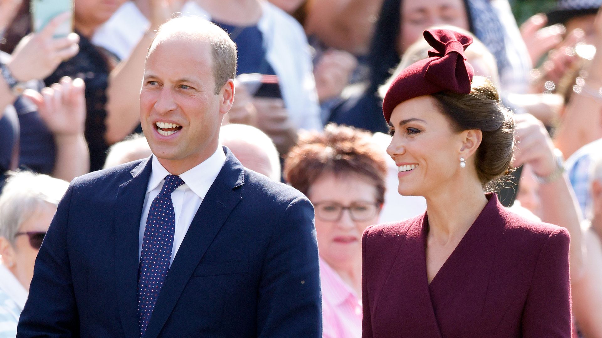 Prince William in a suit and Kate Middleton in a burgundy dress
