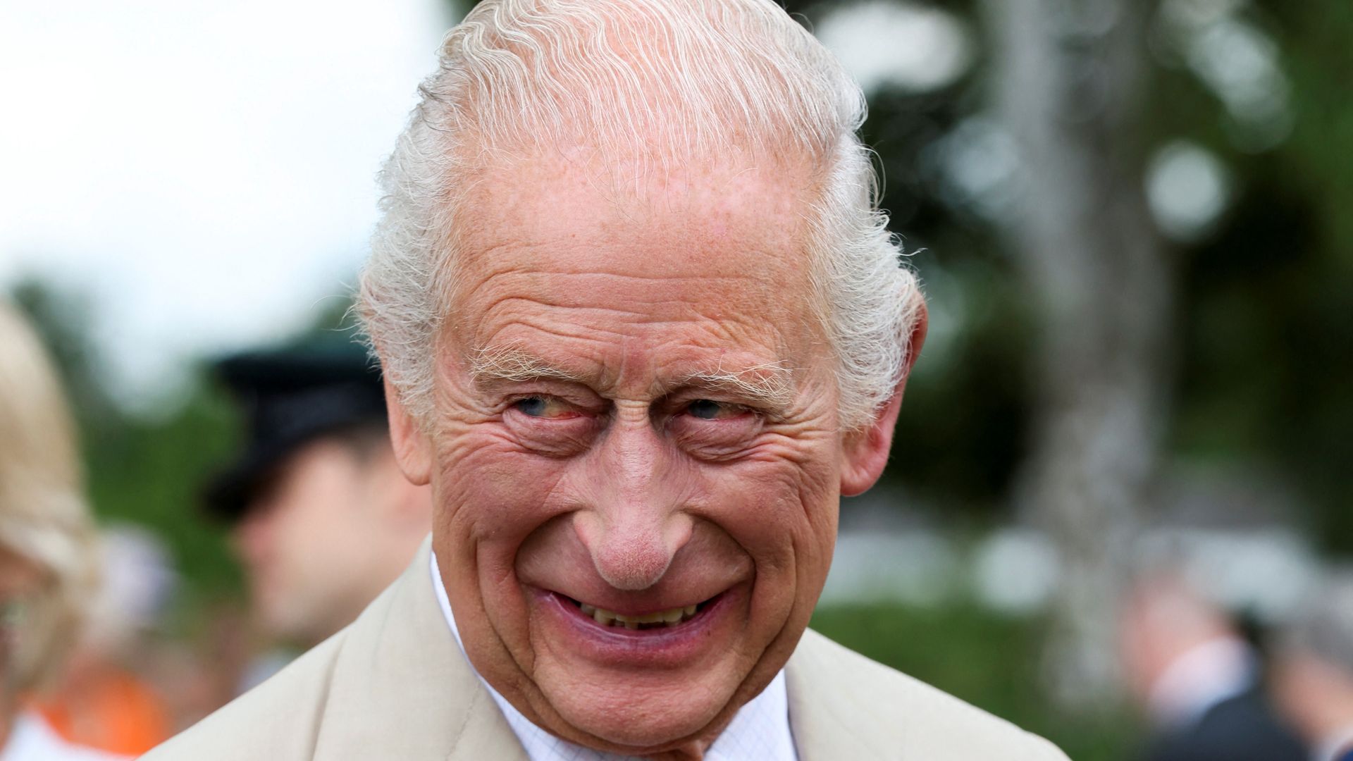 King Charles III smiles and reacts to visiting horses at The National Stud 