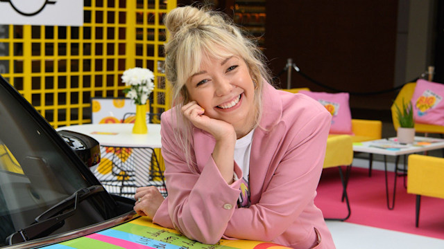 Woman smiling in a pink suit