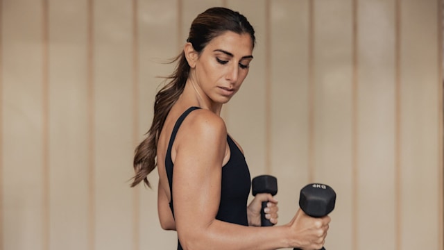 Woman flexing while holding dumbells 