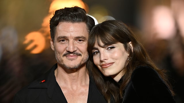 Lux Pascal places hear head on brother Pedro Pascal's shoulder. Both are wearing black. 