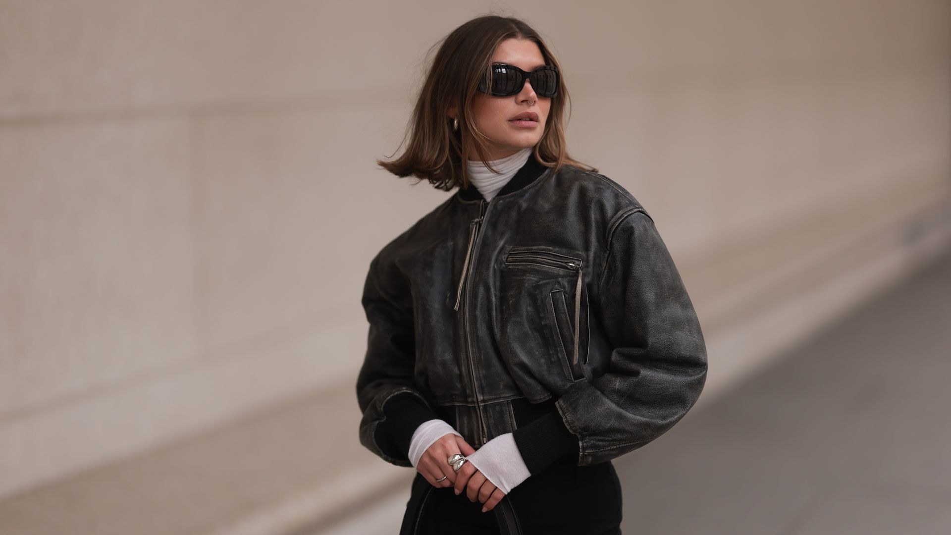 Sophia Geiss is seen wearing Mango black sunglasses, Acne Studios black / grey leather bomber jacket, Intimissimi white sheer high neck cashmere top, Edited black belted long skirt, on February 16, 2024 in Berlin, Germany