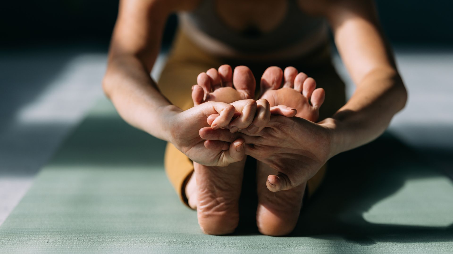 Woman stretching her legs while doing yoga.