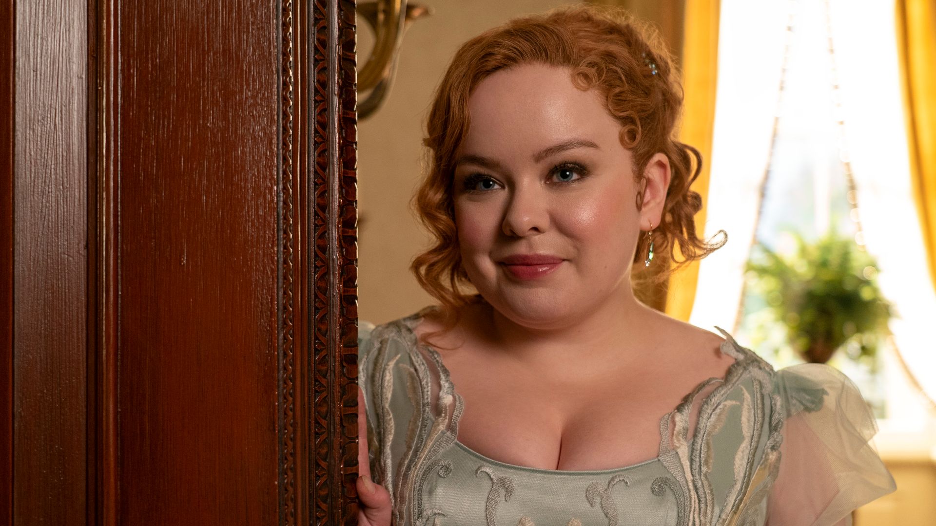 young woman with curly red hair in green dress