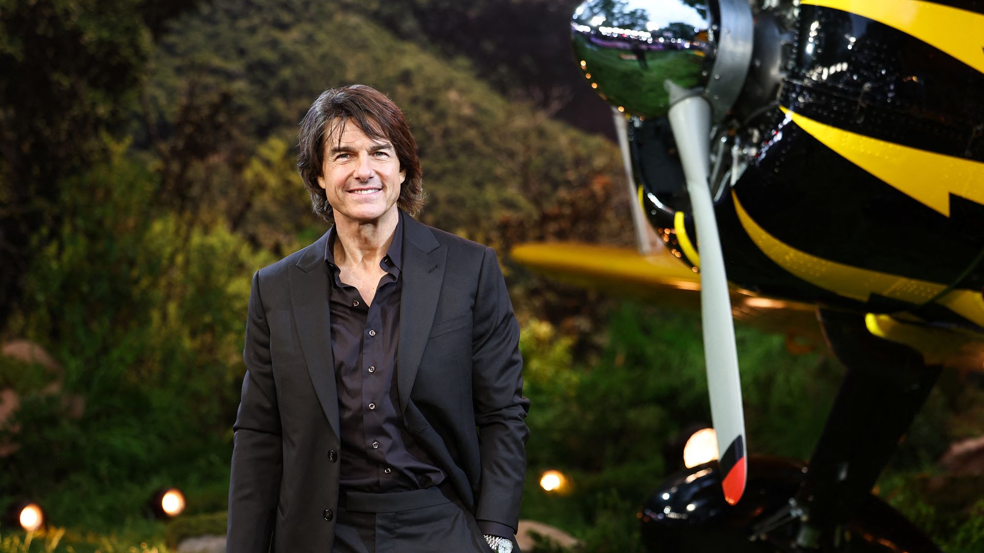 man in black suit next to plane