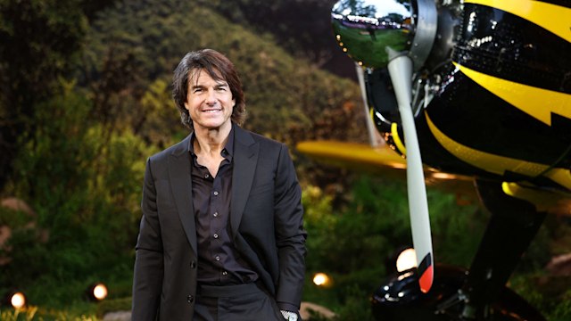 man in black suit next to plane