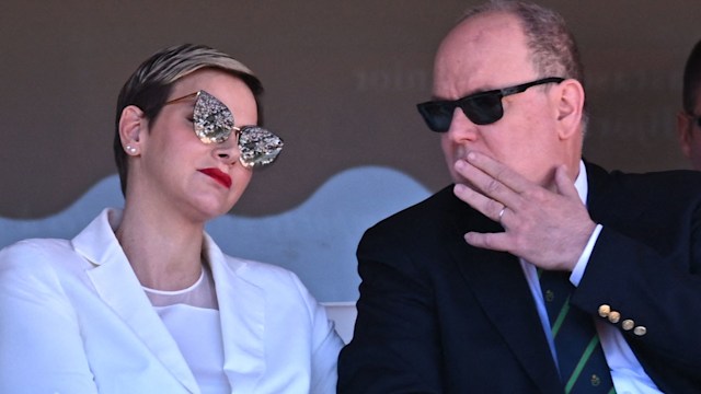 Prince Albert whispering to Princess Charlene in sunglasses