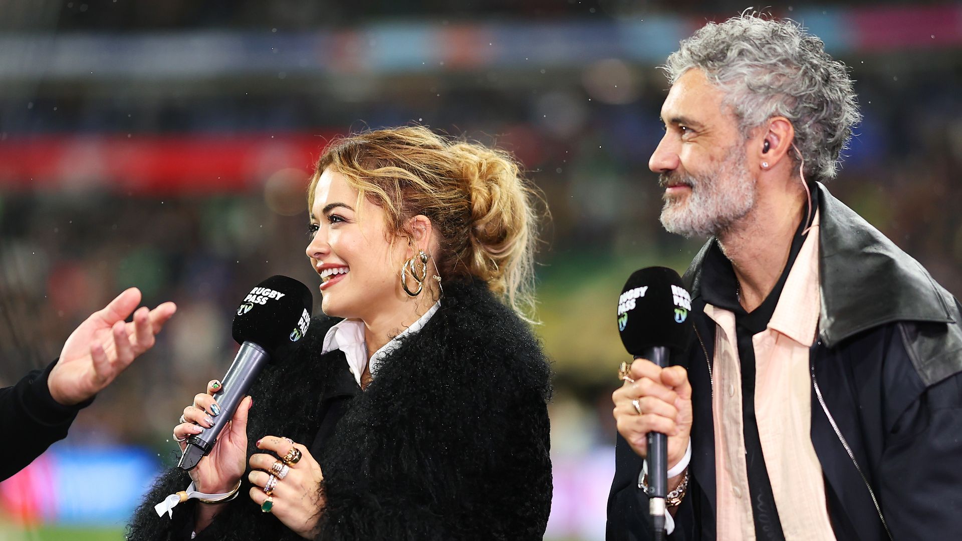 Rita Ora and Taika Waititi being interviewed at the Rugby World Cup