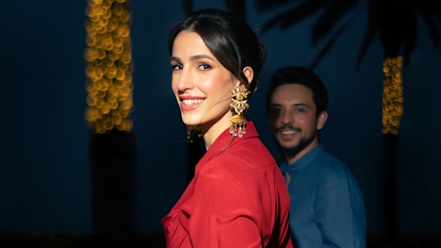 Princess Rajwa wearing red dress and gold earrings