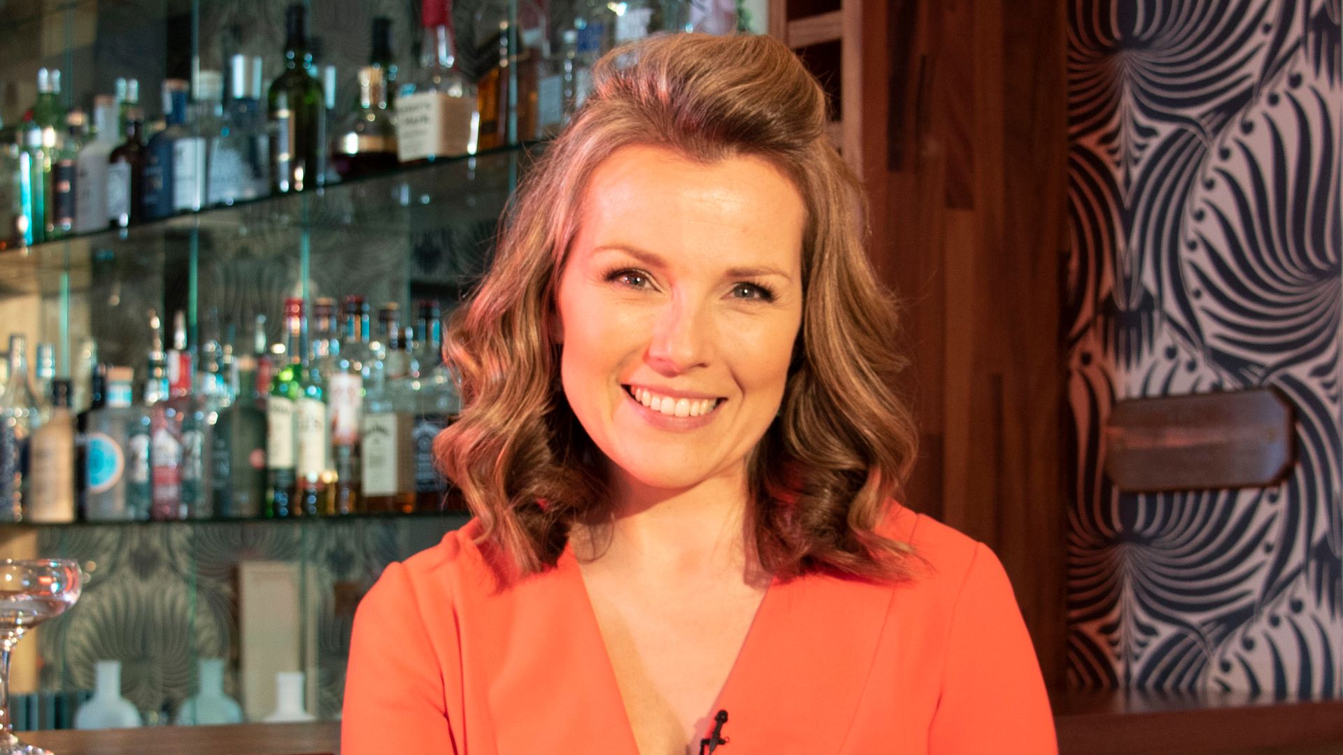 tv presenter smiling in restaurant/bar