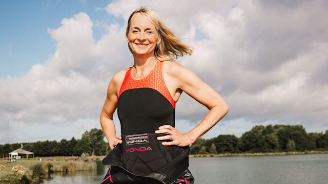 Louise Minchin stands in front of river in wet suit