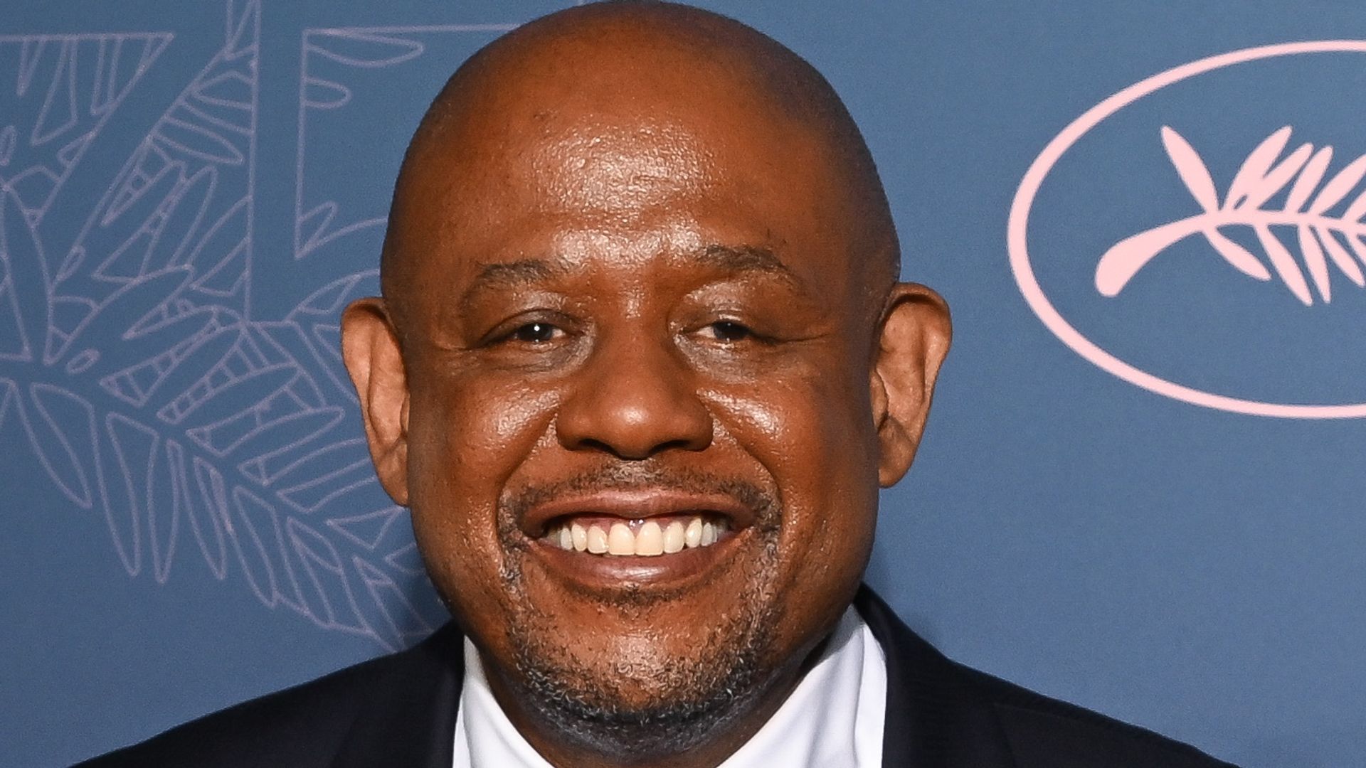 Forest Whitaker smiling in a suit 
