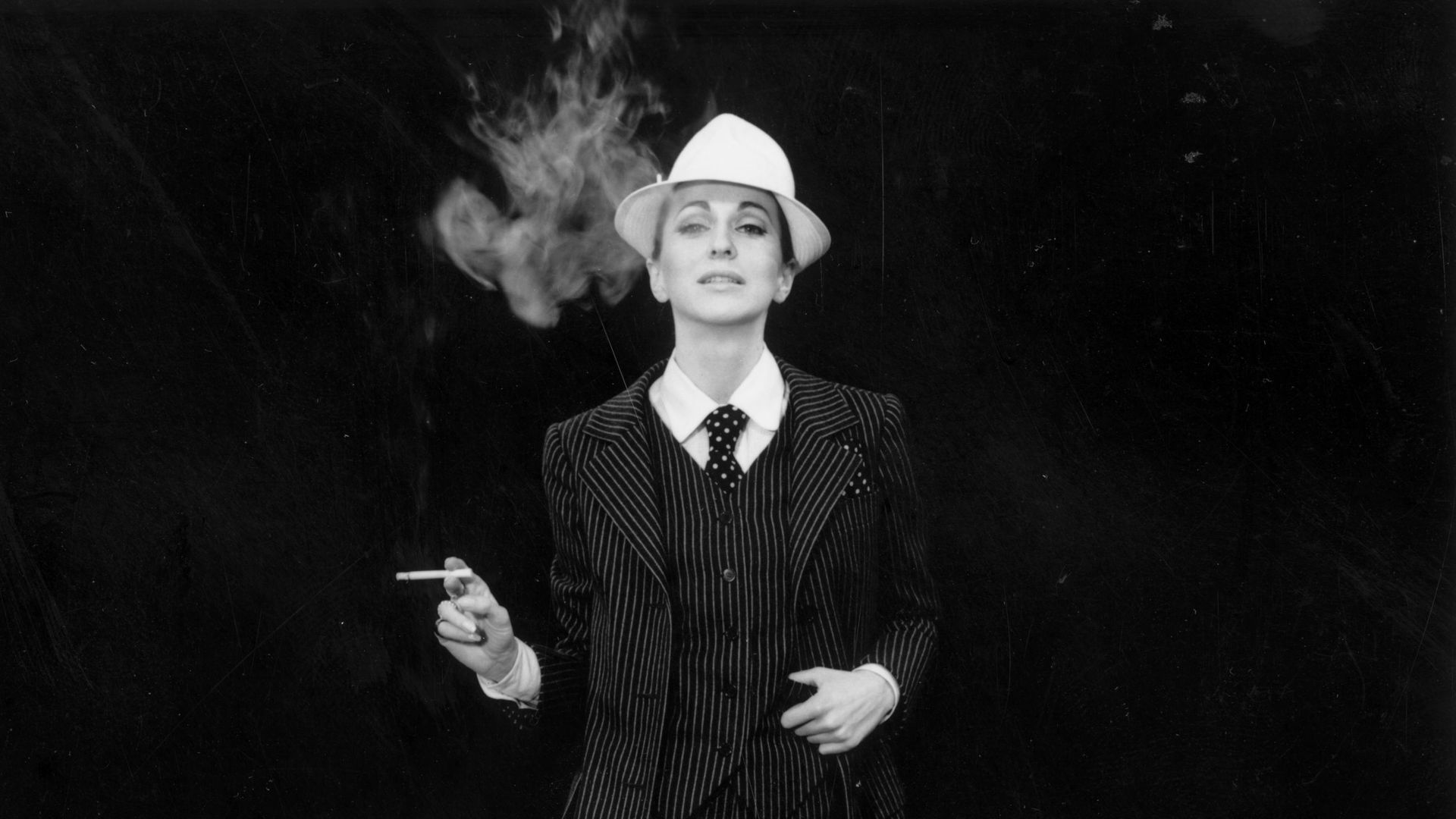A model strikes a masculine look wearing a pinstriped trouser suit by Yves Saint Laurent, 23rd February 1967. His plainer suit for evening wear known as 'Le Smoking' became his signature piece.  (Photo by Reg Lancaster/Daily Express/Hulton Archive/Getty Images)