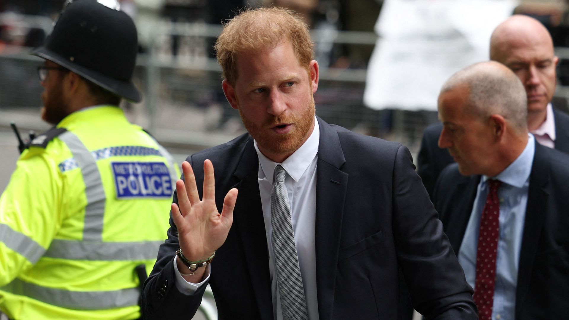 Prince Harry waves as he arrives at High Court