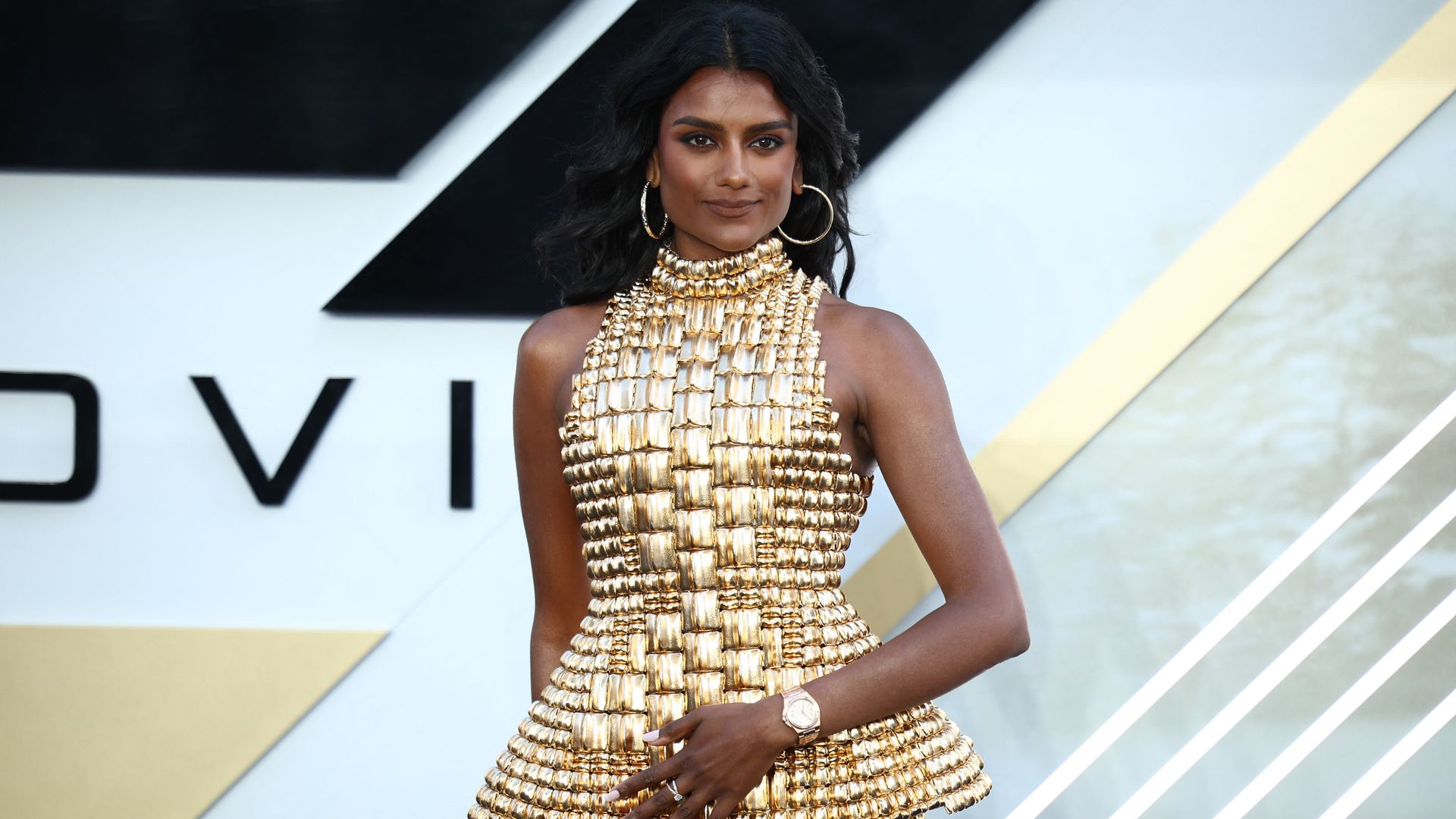 simone ashley in gold peplum dress