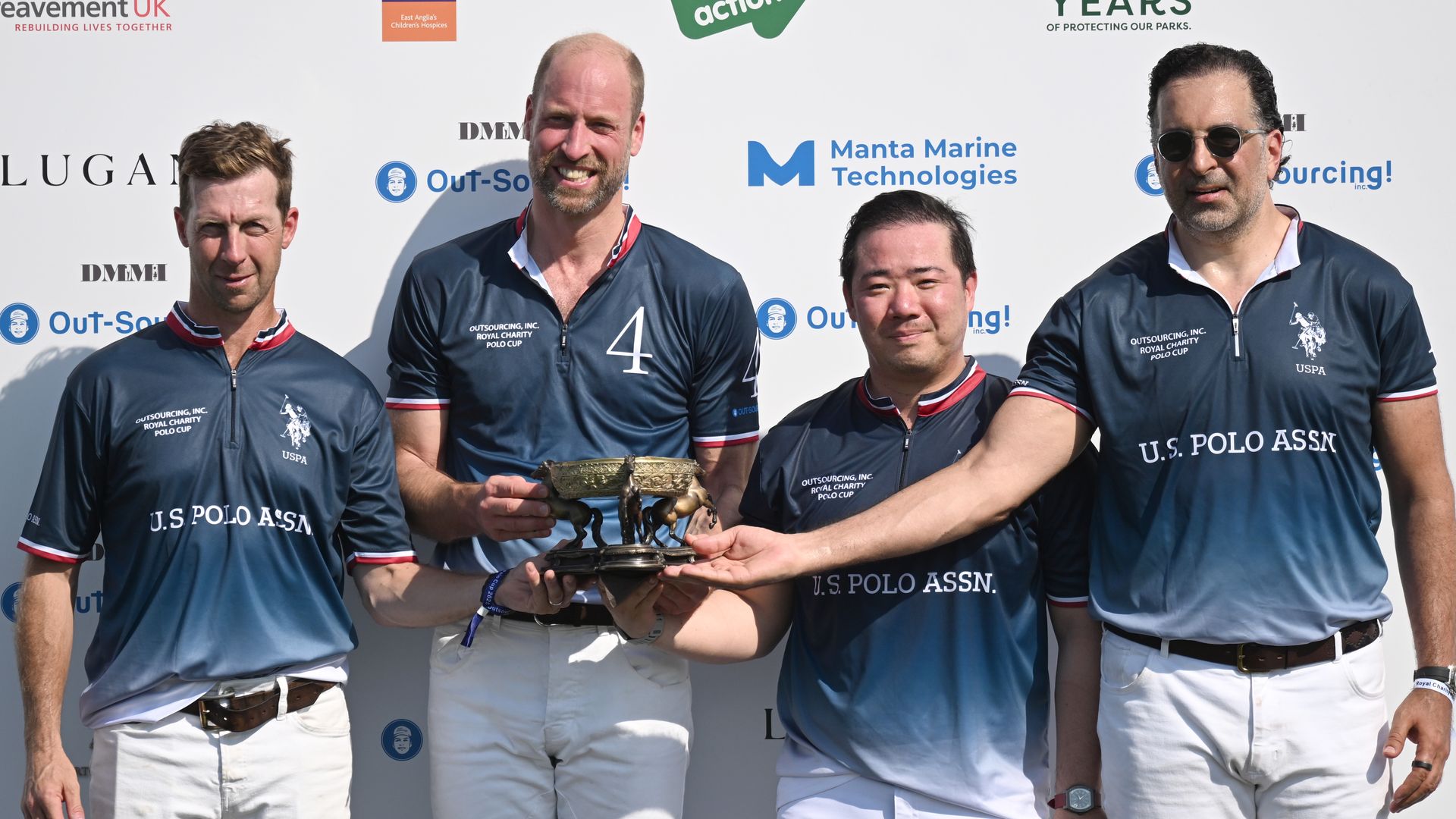 Prince William and three men with a trophy