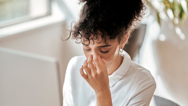 Burnout, stress and business woman in office feeling pain, exhausted or migraine. Headache, mental health and anxiety of tired female employee overworked, stressed and depressed in company workplace.