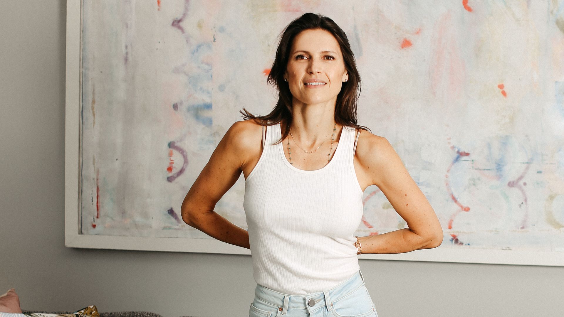woman in jeans and a white top posing at home 