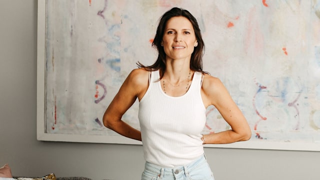 woman in jeans and a white top posing at home 