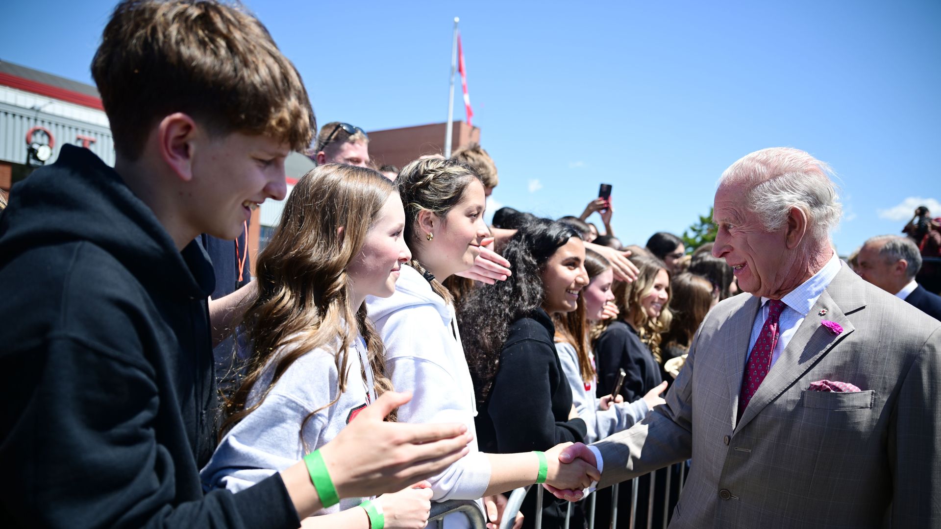 King Charles shaking hands with school children