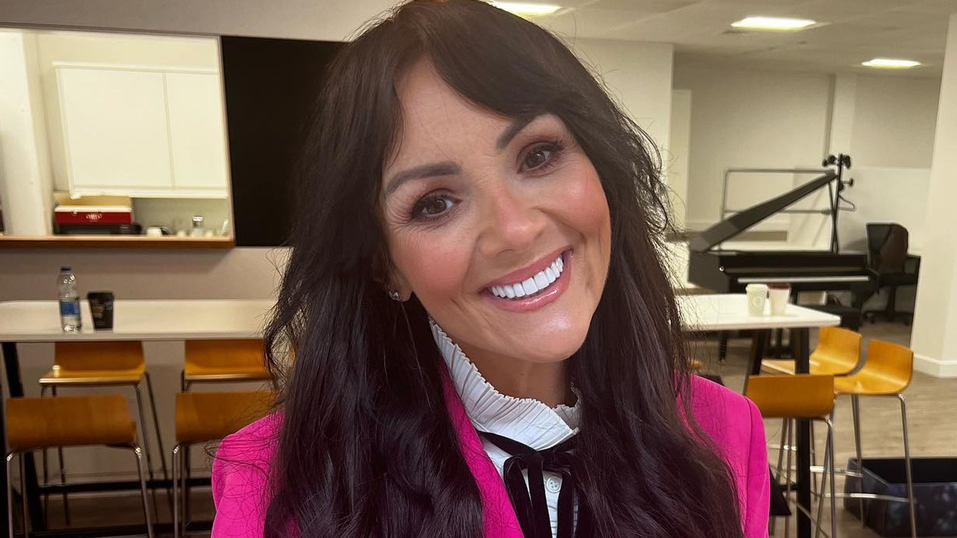Martine McCutcheon in a close up photo smiling and wearing a magenta blazer
