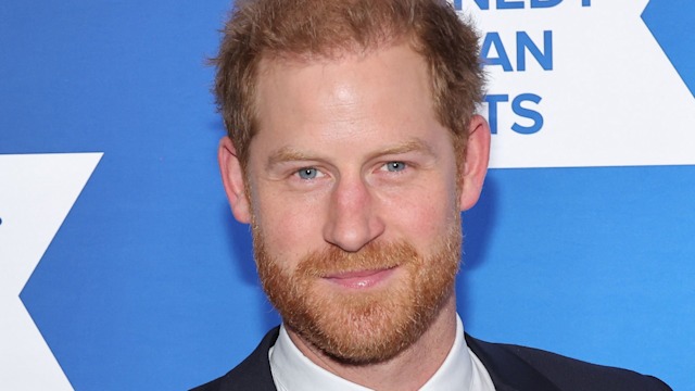 Prince Harry smiling for a red carpet photo