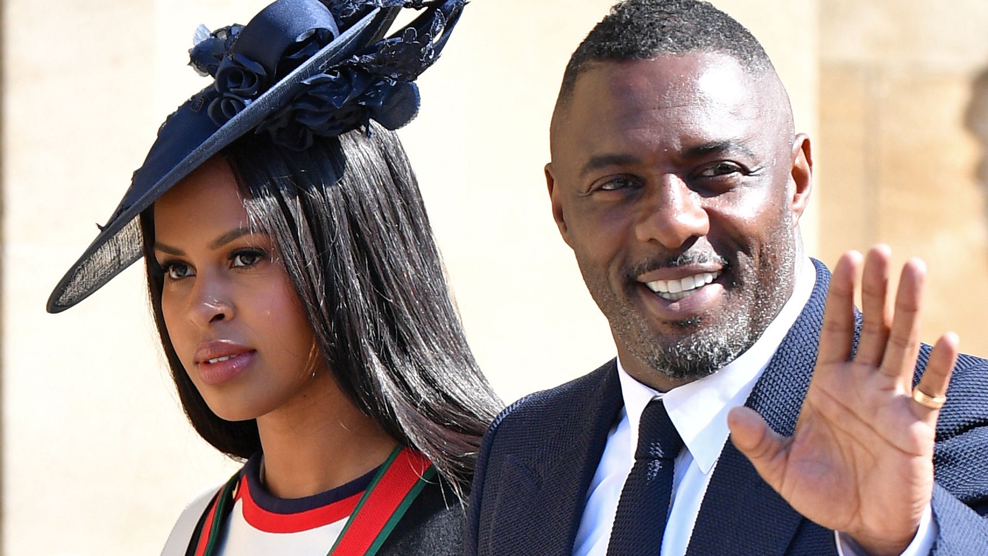 Idris Elba waving alongside his wife Sabrina as they attended the wedding of Prince Harry and Meghan Markle