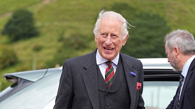 King Charles in a kilt smiling widely