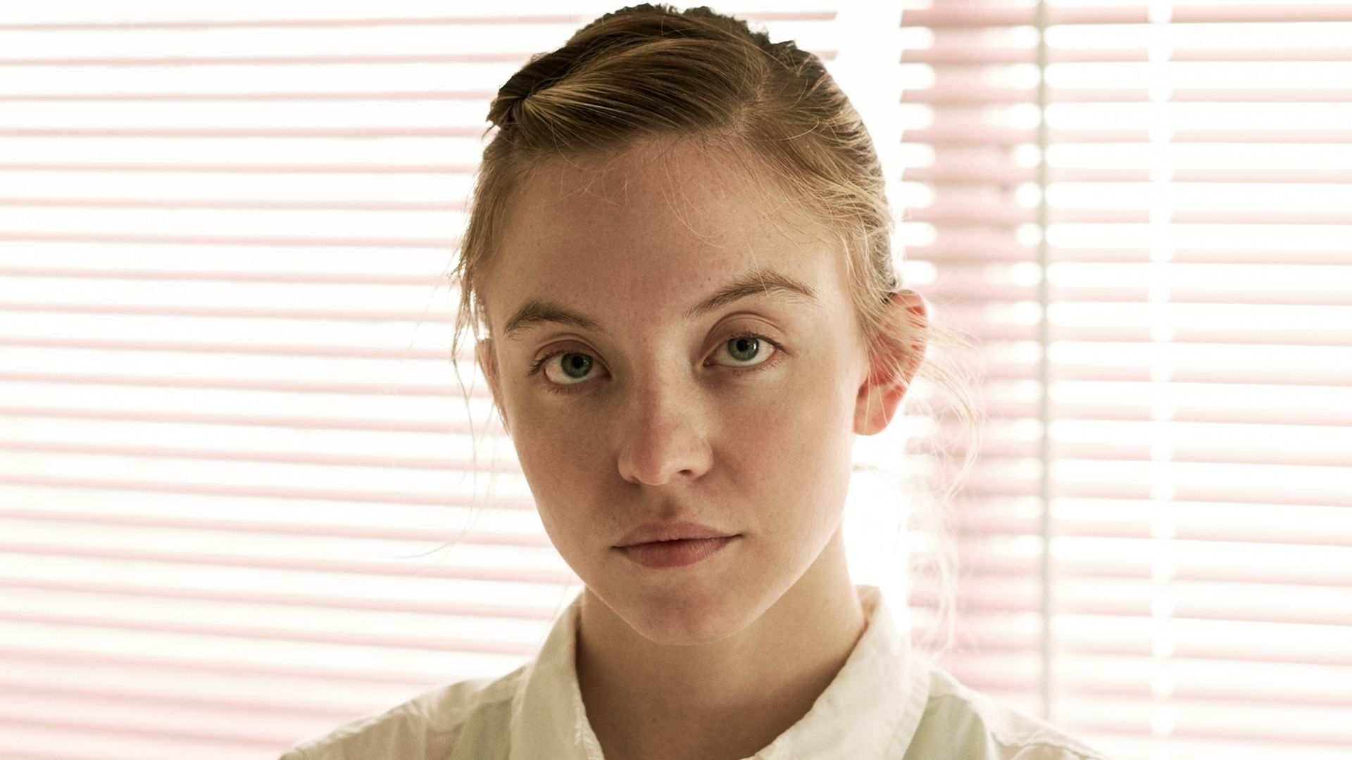 A woman looks into the camera