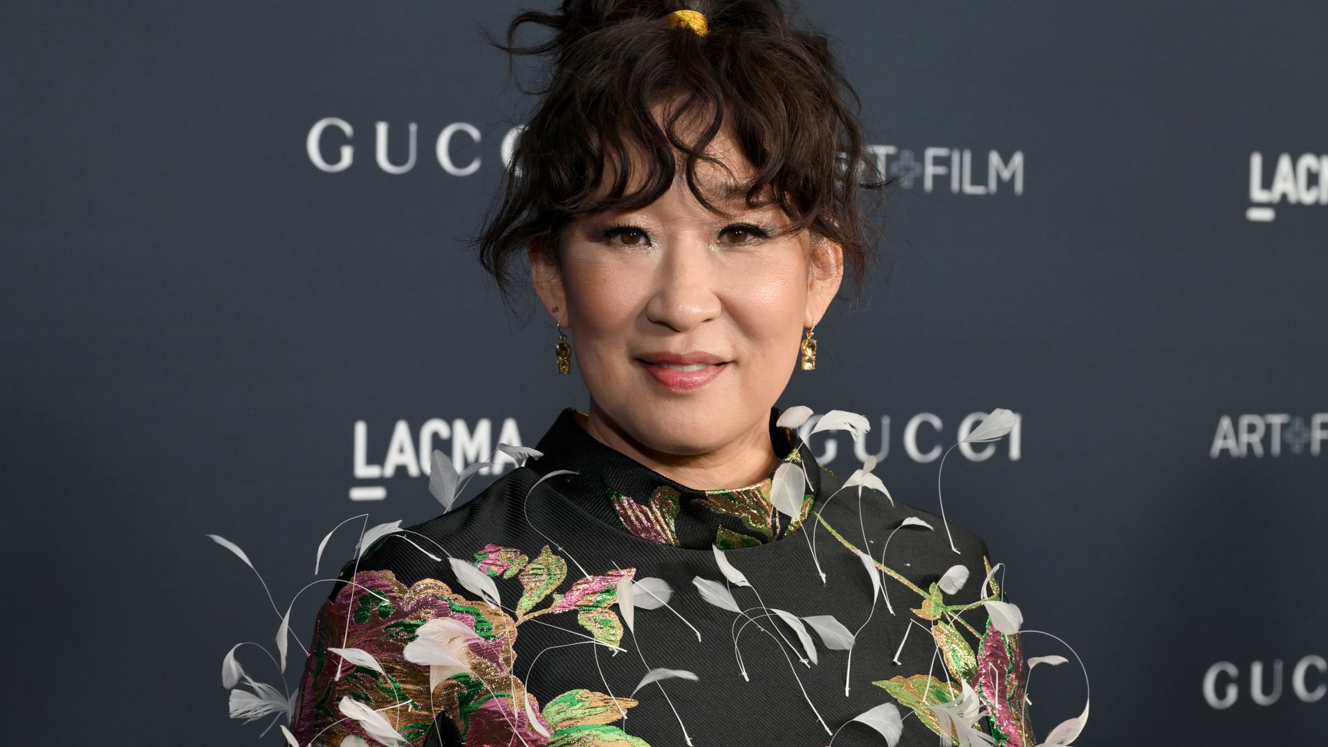Sandra Oh smiling for a red carpet photo