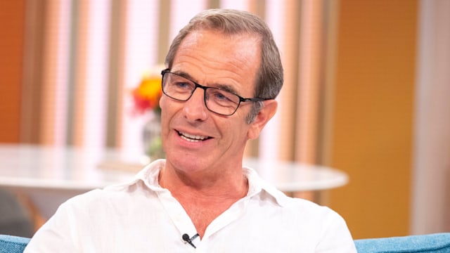 Man in white shirt sitting on blue sofa in tv studio
