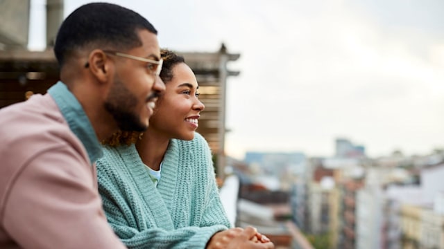 Couple Looking Away While Holding Hands At Rooftop