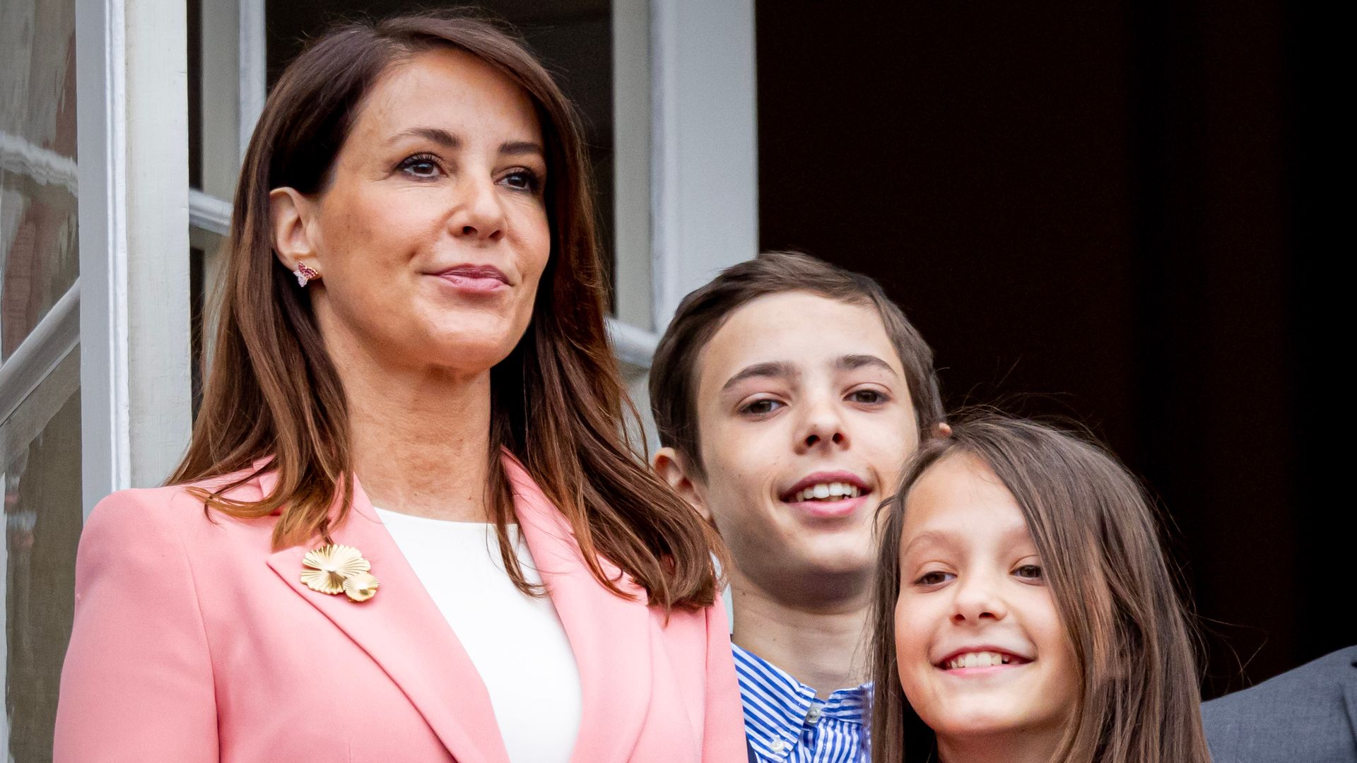 Princess Marie, Count Henrik and Countess Athena standing on a balcony