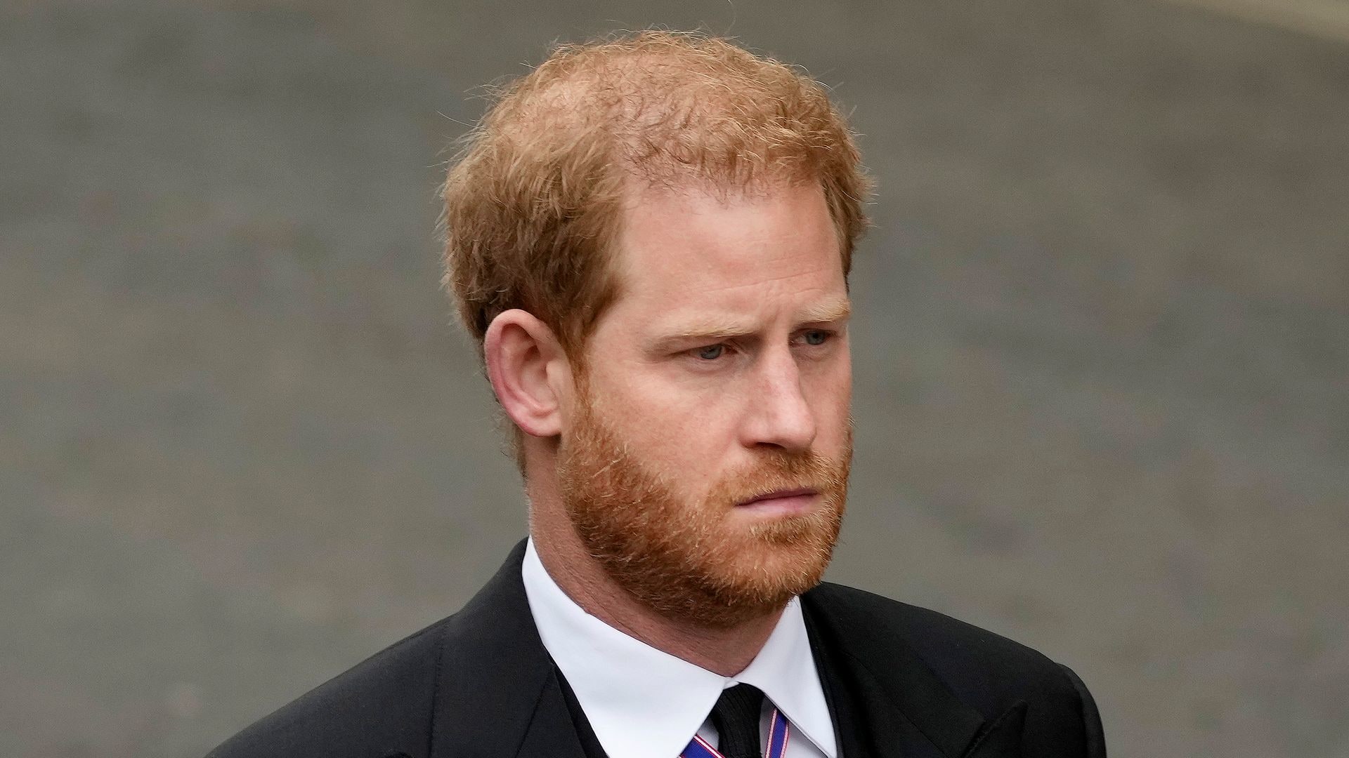 Prince Harry looking sombre in a black suit